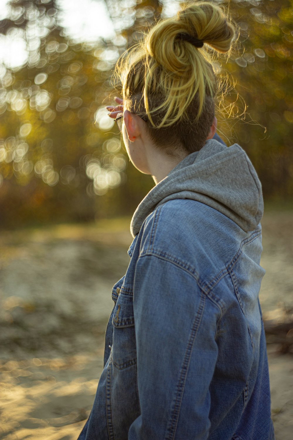 a woman with a pony tail in a denim jacket