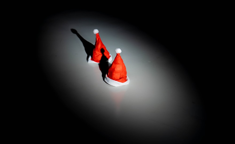 a pair of red santa hats sitting on top of a table