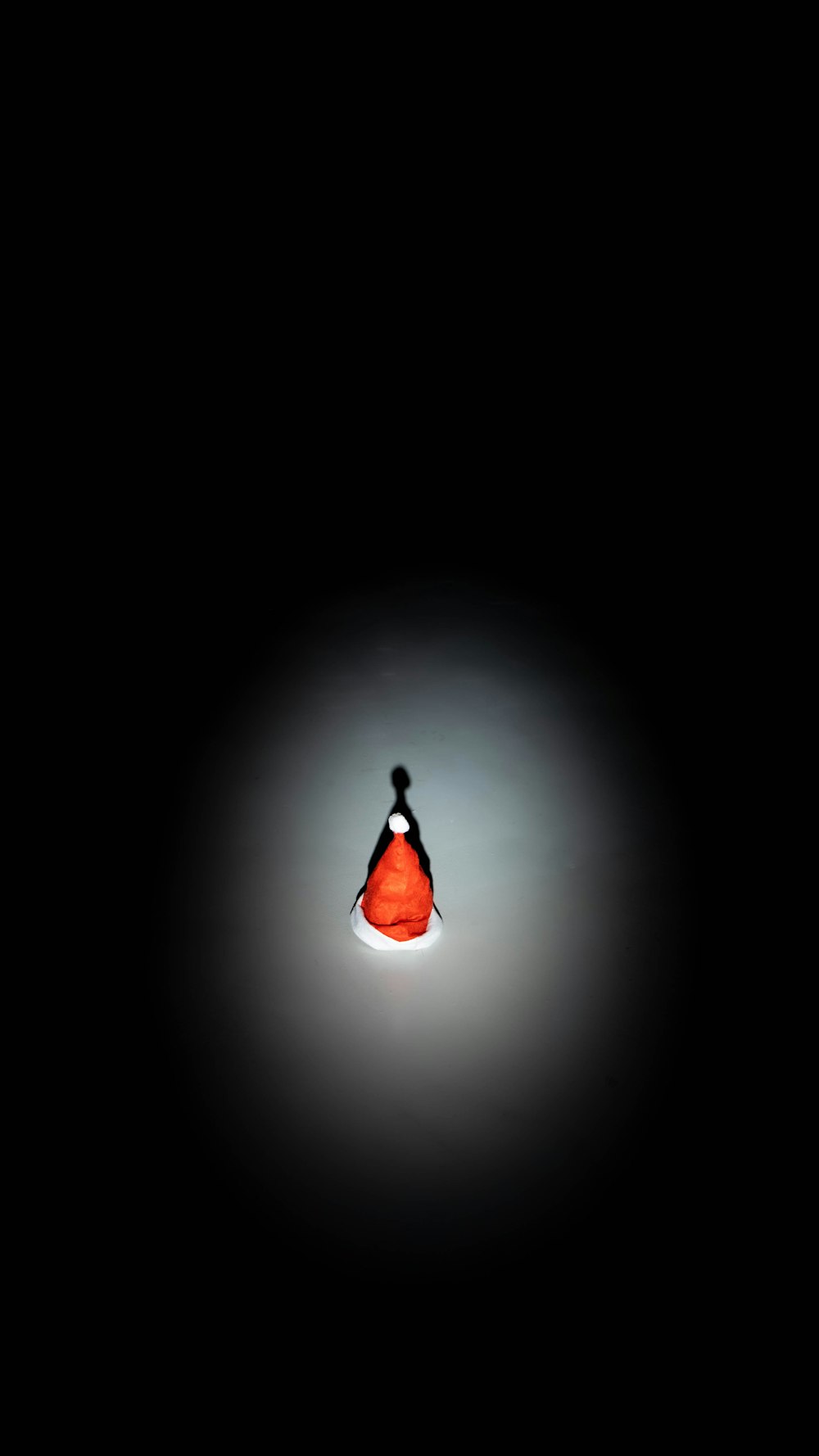 a person standing in the dark with a red umbrella