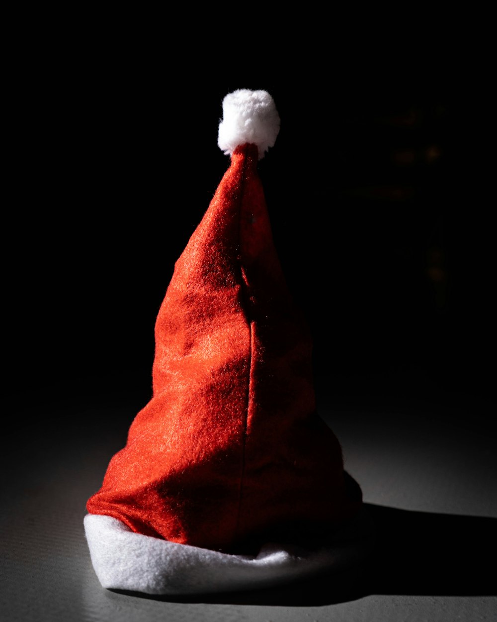 um chapéu de Papai Noel vermelho sentado em cima de uma mesa