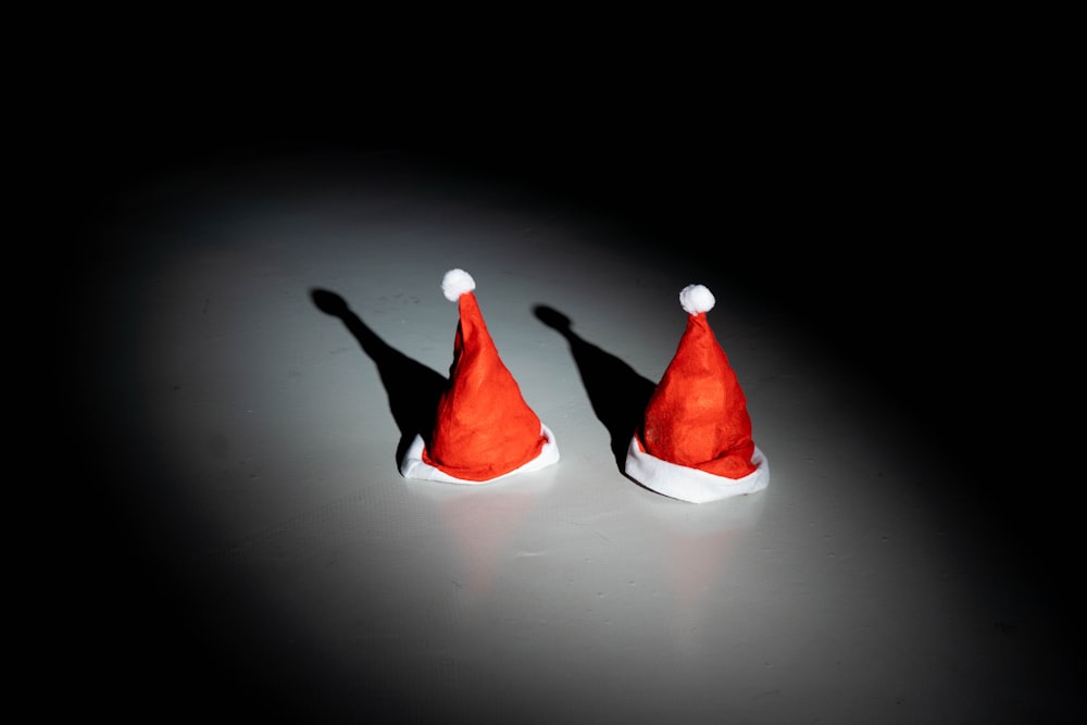 two red santa hats sitting on top of a table