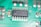 A close-up view of a green printed circuit board featuring an integrated circuit chip marked with the text 'HCF4069U GZ0Q335'. The board also contains various small electronic components such as resistors and capacitors, and conductive traces that form connections between components.