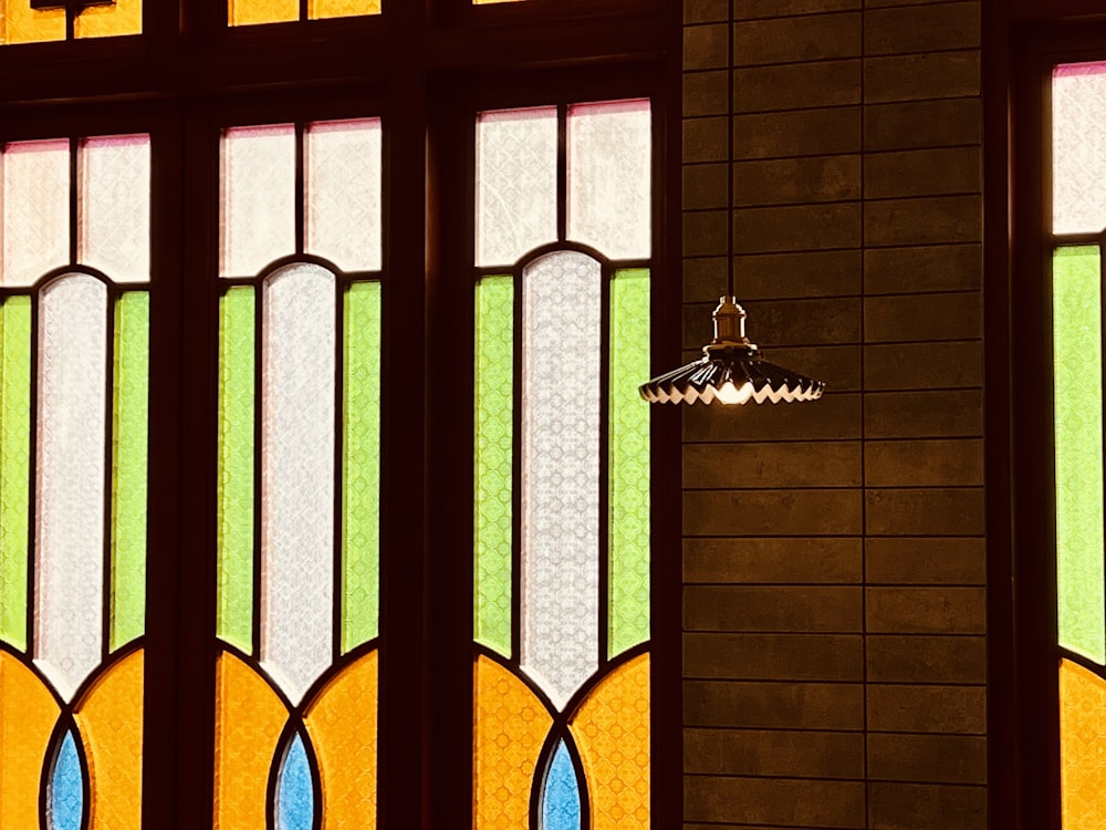 a stained glass window with a light hanging from it's side