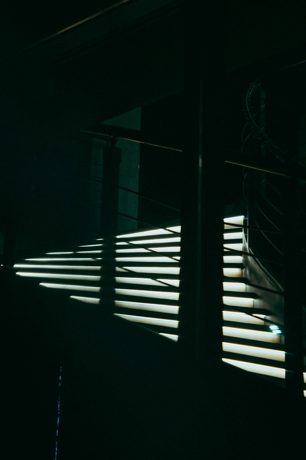 a dark room with a window with blinds on it