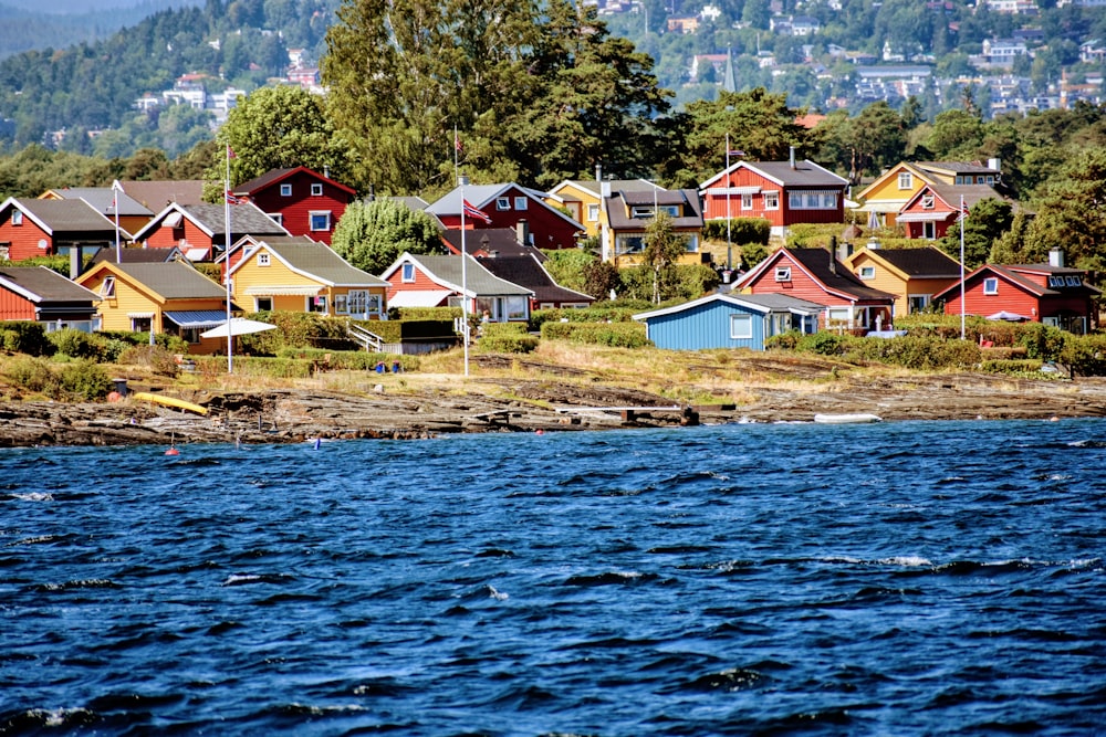 a row of houses sitting on the shore of a lake