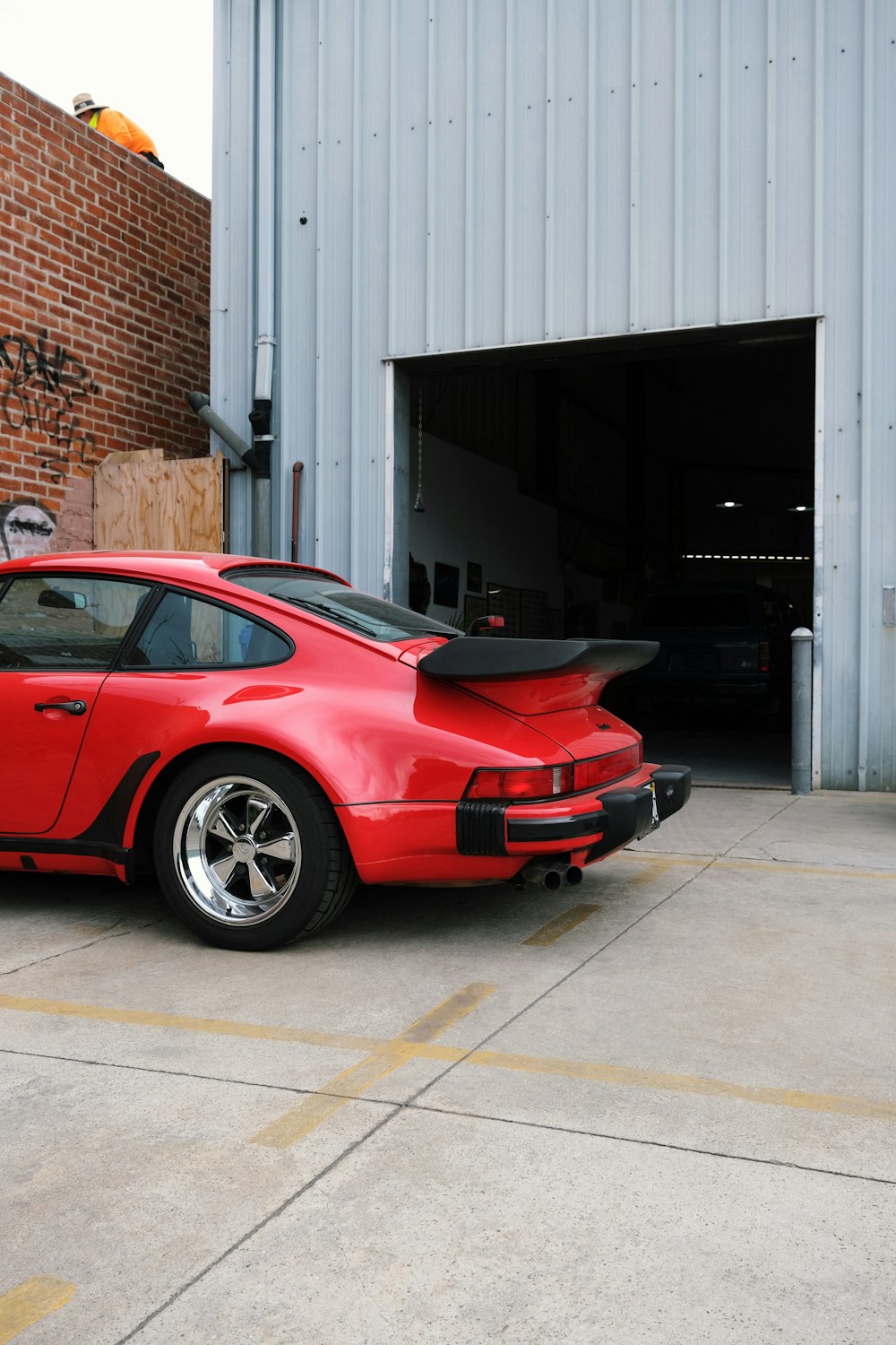 a red sports car parked in front of a garage