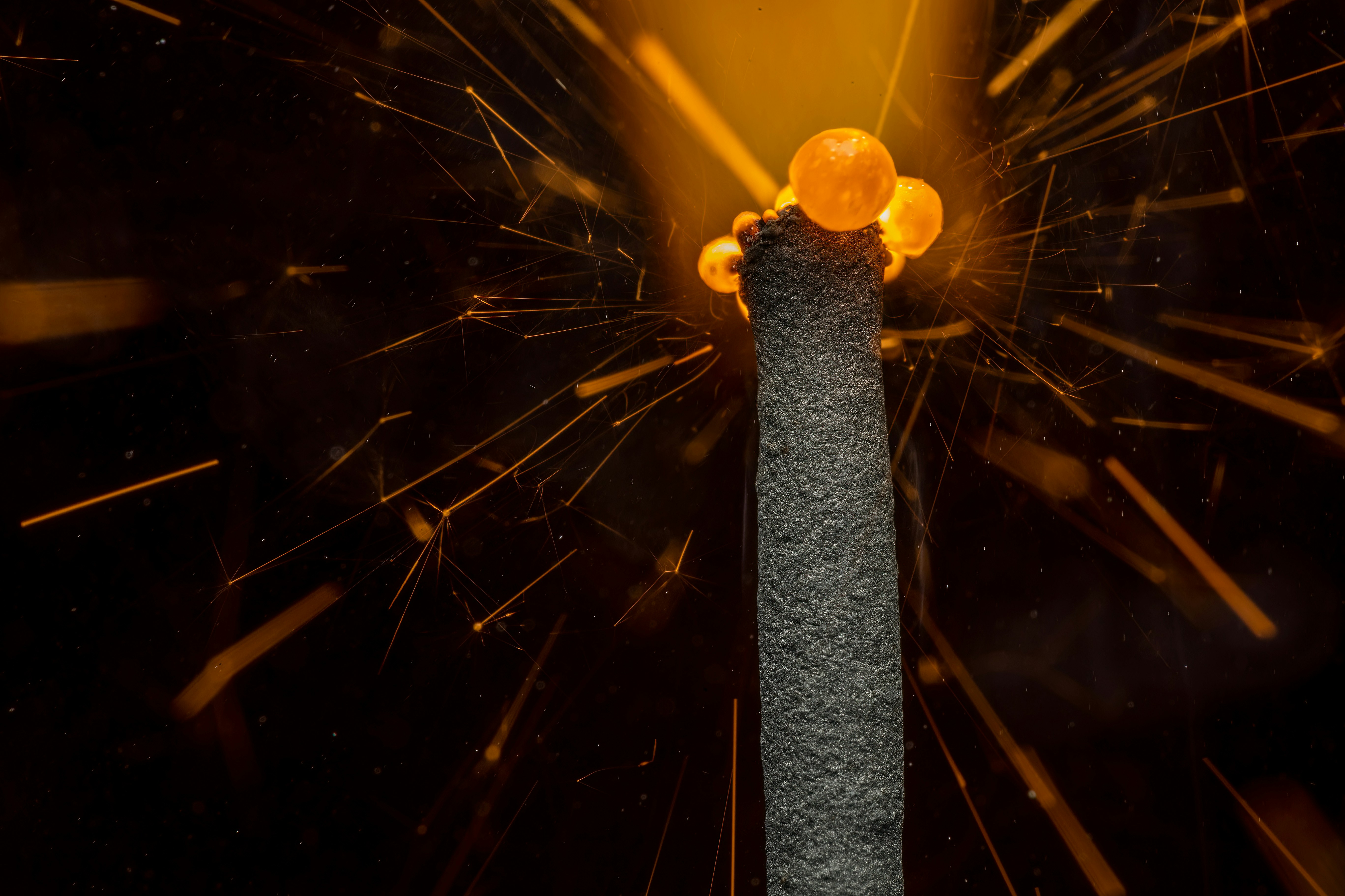 Un primer plano de una pieza de metal con chispas que salen de ella