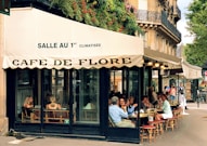 a group of people sitting outside of a cafe