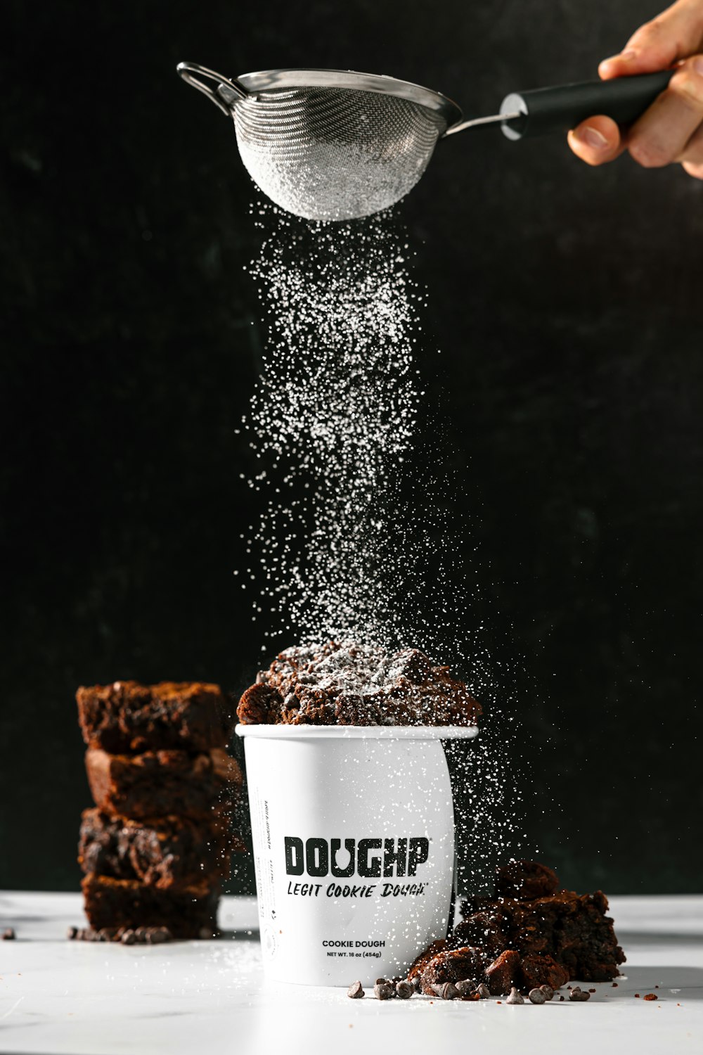 a cup of coffee being sprinkled with sugar
