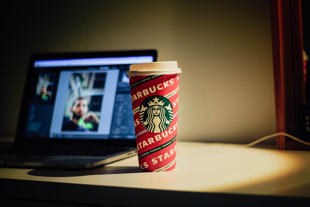 a starbucks cup sitting next to a laptop computer