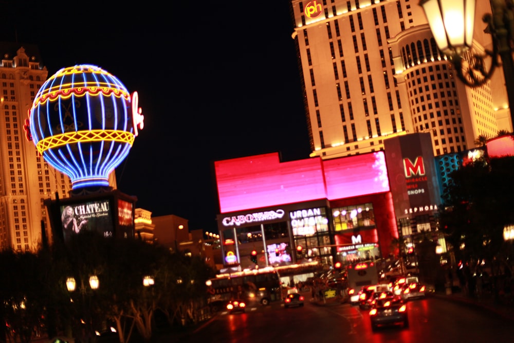 a view of a city at night with a hot air balloon in the sky