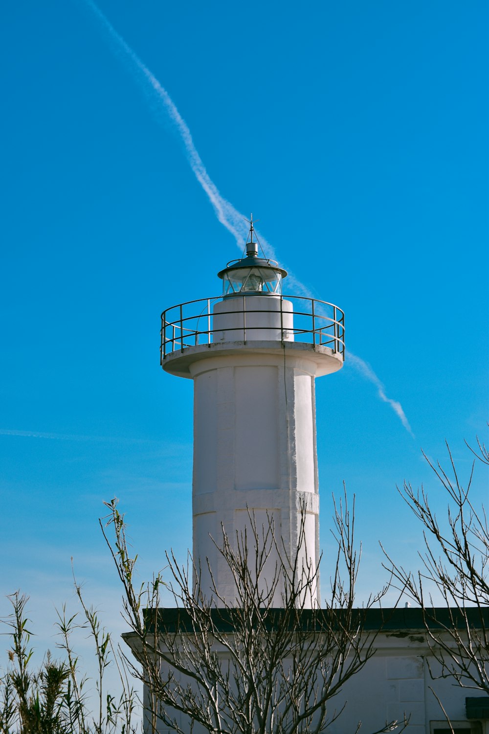 a white lighthouse with a blue sky in the background