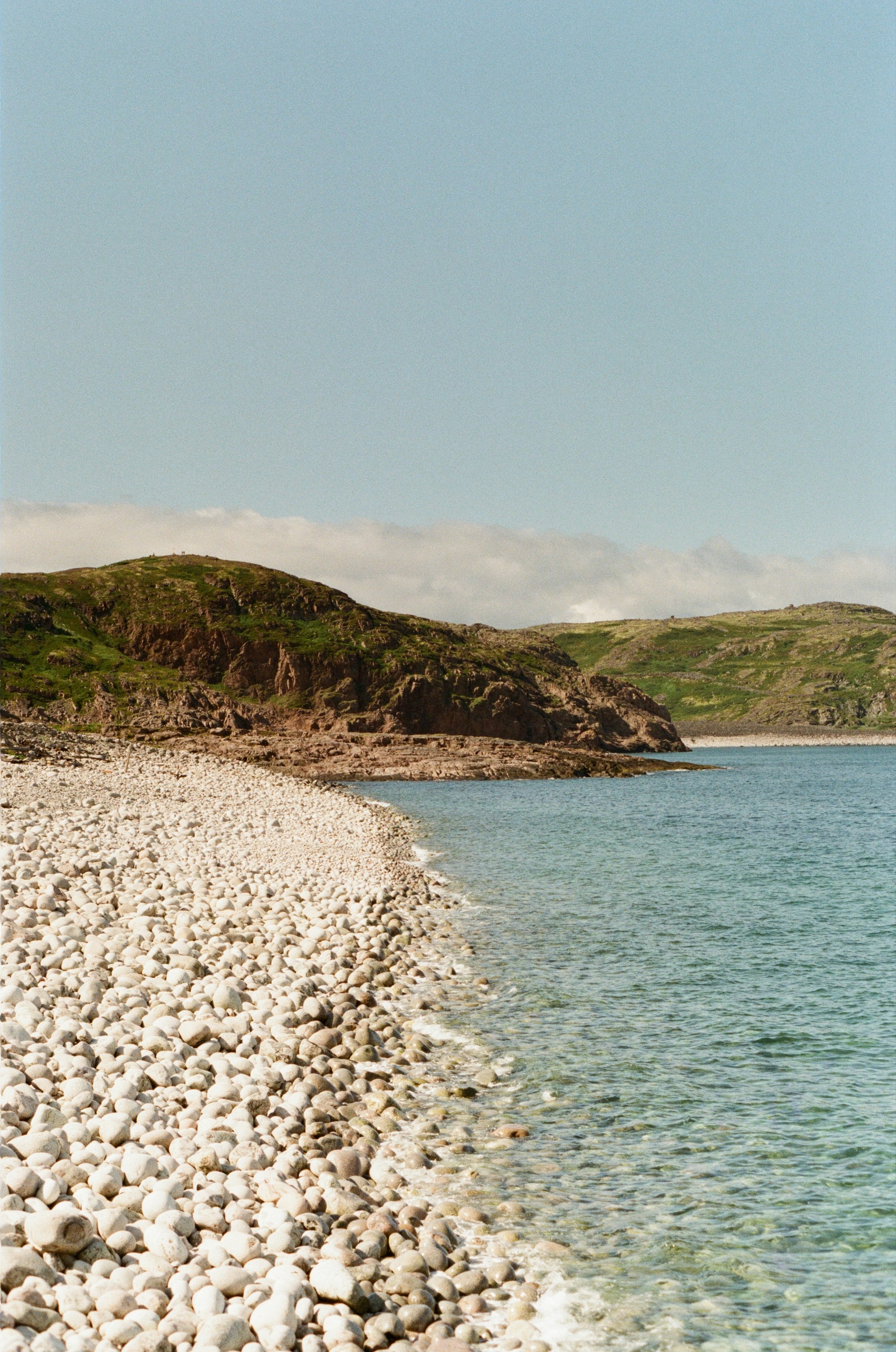 a rocky beach with a boat in the water
