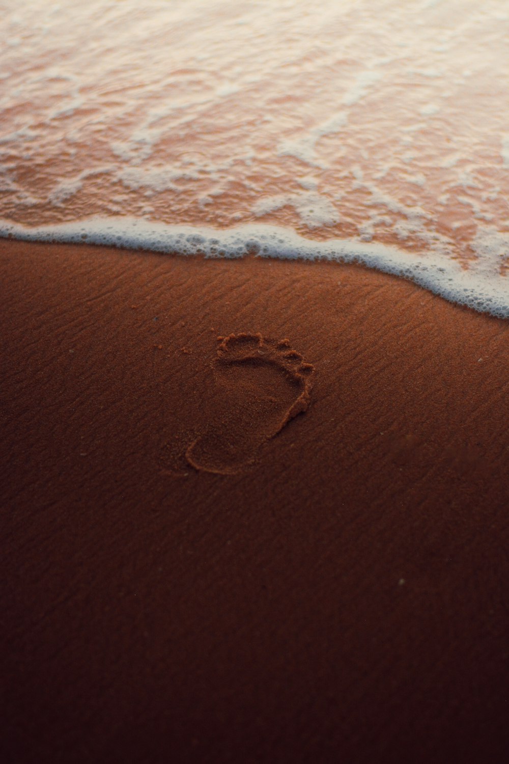a foot print in the sand on a beach