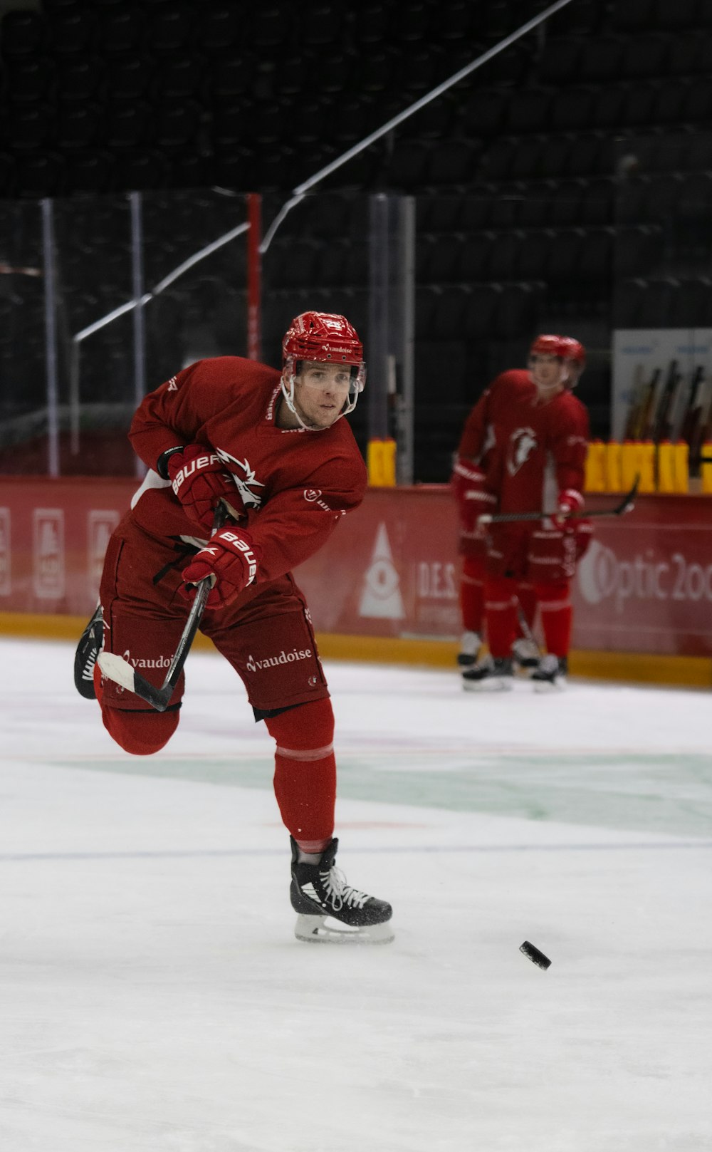 a man in a red uniform skating on an ice rink