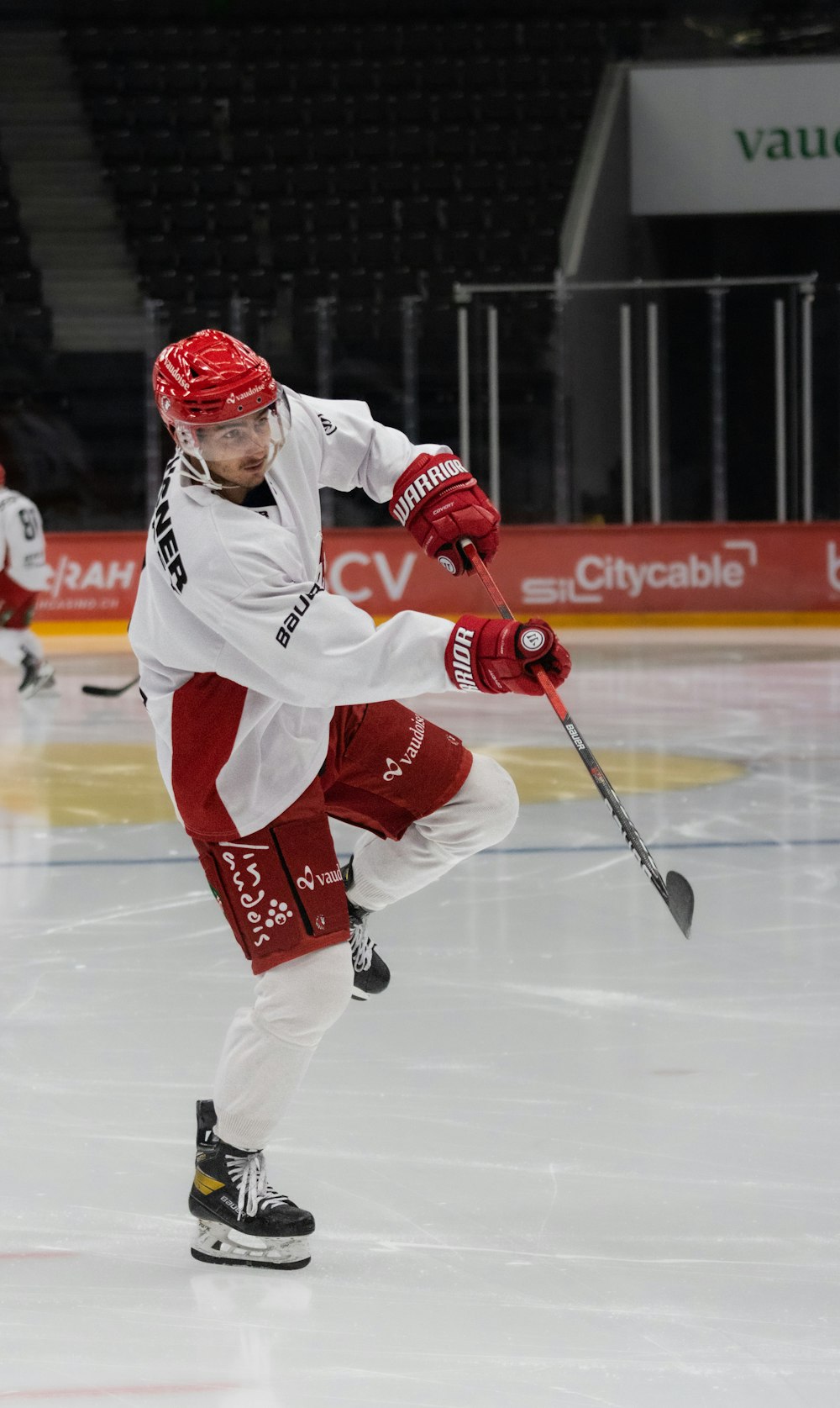 a man in a red and white uniform skating on an ice rink