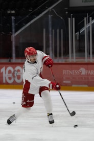 a man in white and red uniform playing a game of ice hockey