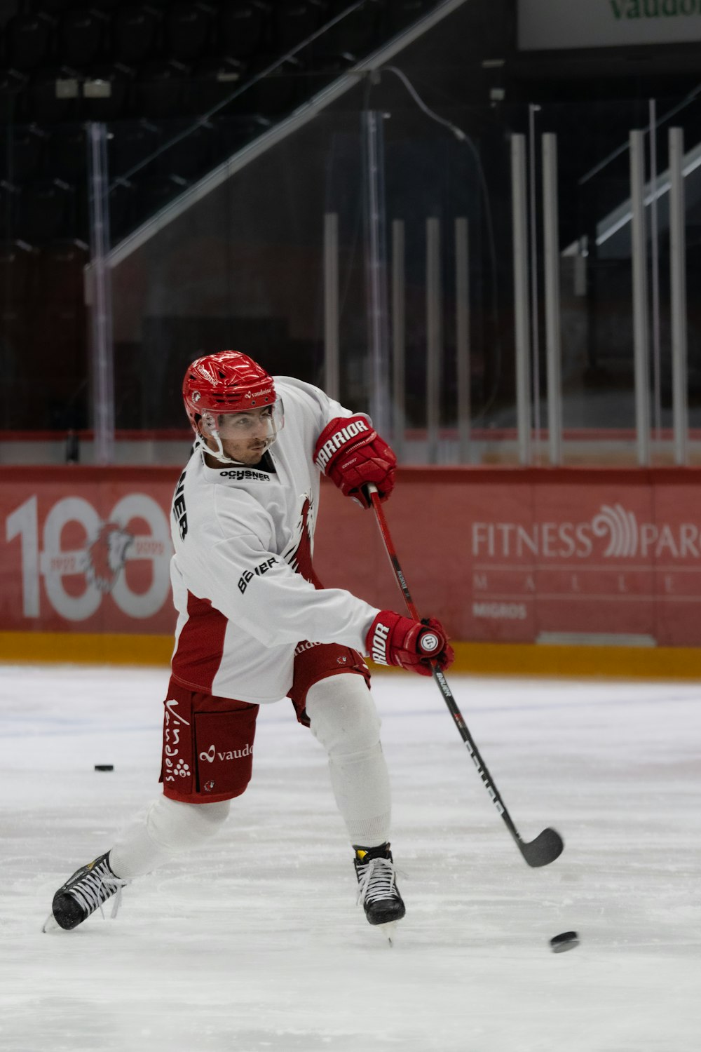 a man in white and red uniform playing a game of ice hockey