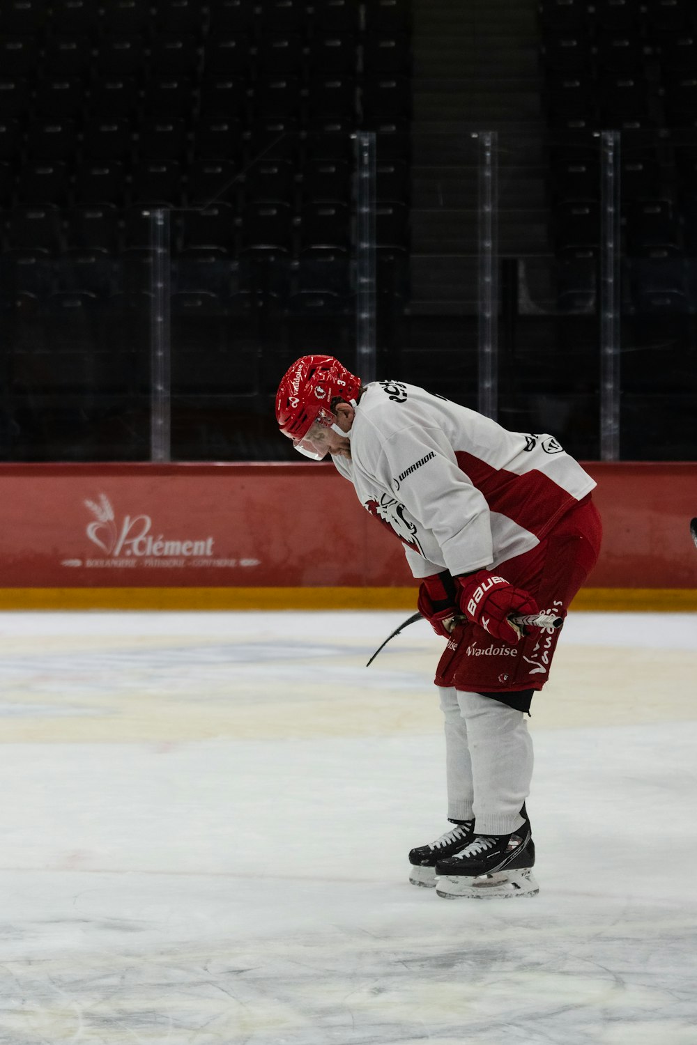 a man in a red and white uniform skating on an ice rink