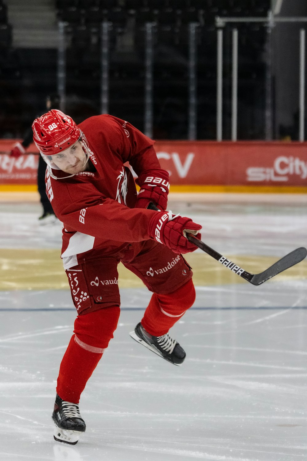 a man in a red uniform skating on an ice rink