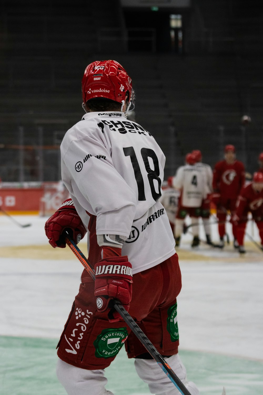 a hockey player in red and white uniform holding a stick