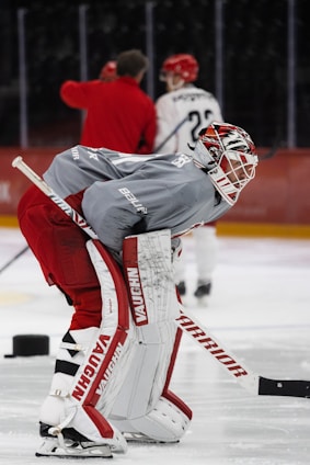 a hockey goalie with his head on the goalie's back