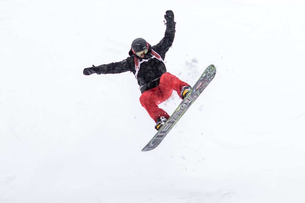 a man flying through the air while riding a snowboard