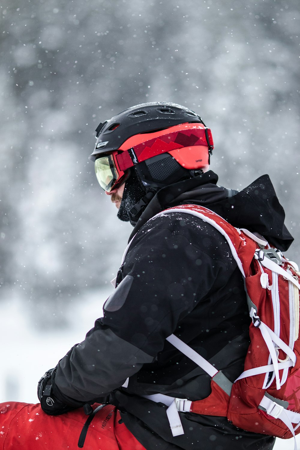 a man with a red backpack and ski goggles