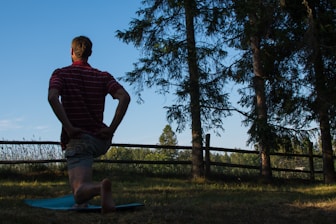 a man standing on a surfboard in the grass
