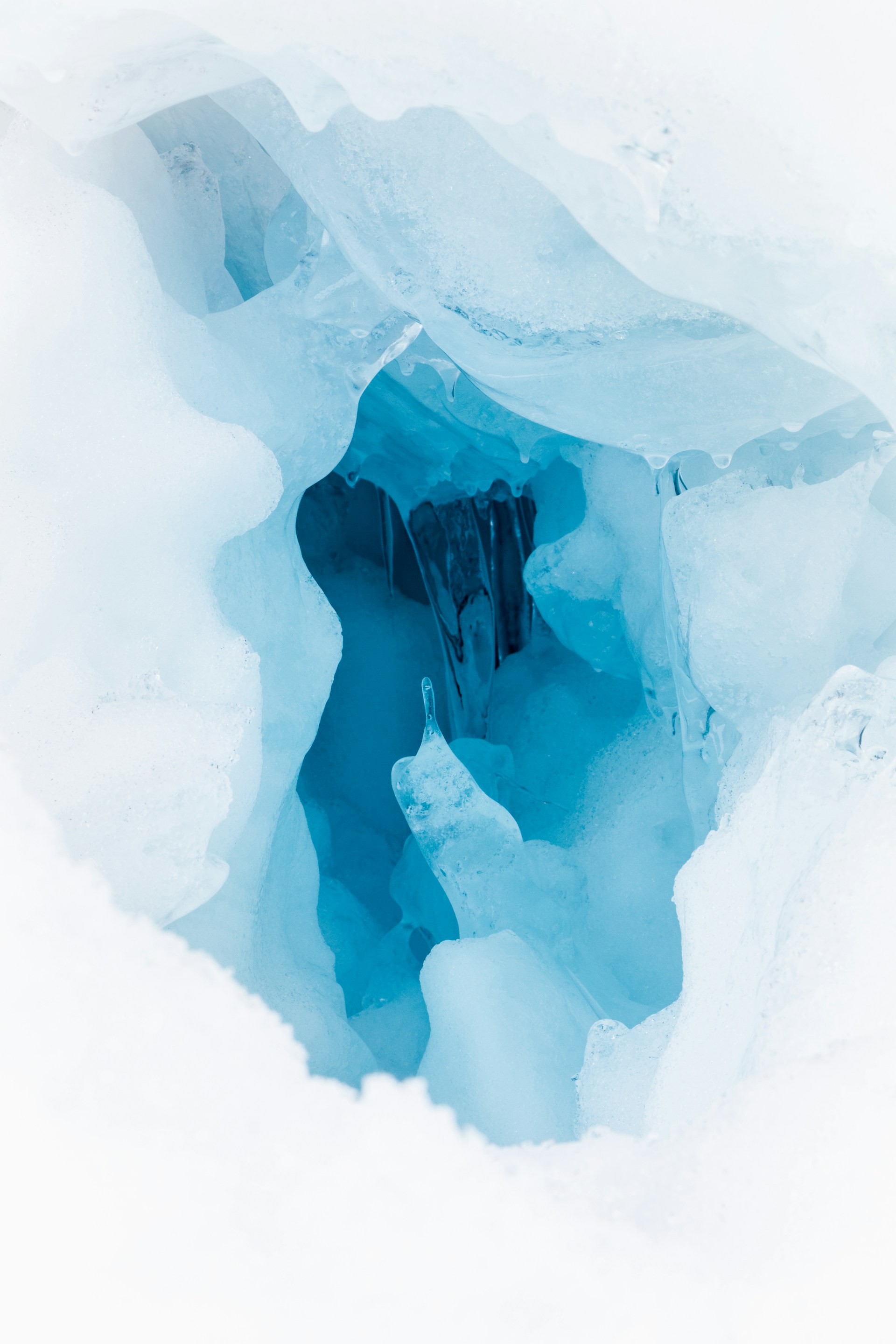 a hole in the ice that looks like an ice cave
