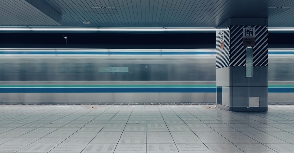 a subway station with a train passing by