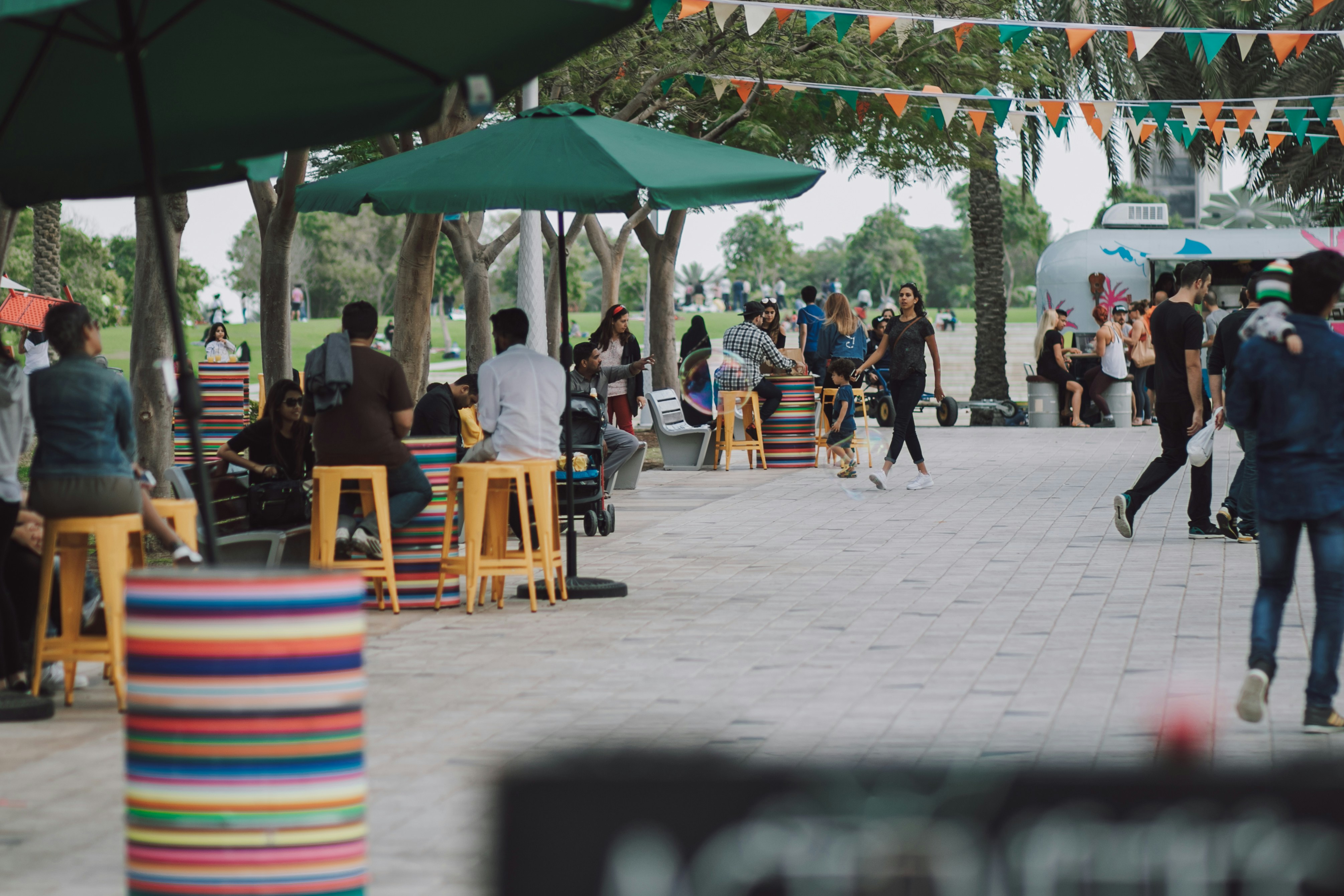a group of people sitting at tables under umbrellas