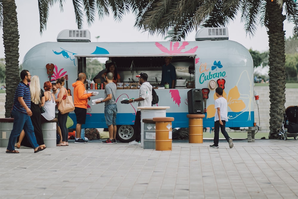 a group of people standing around a food truck