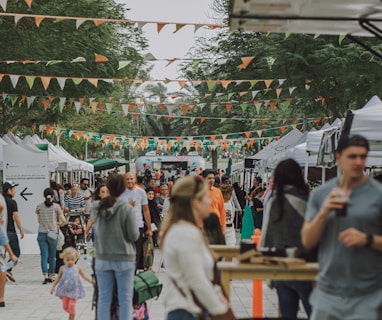 a crowd of people walking around a market