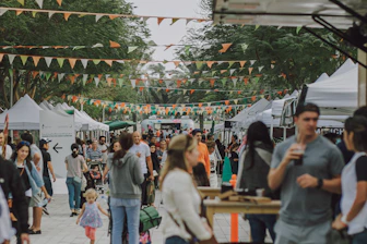 a crowd of people walking around a market