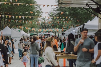 a crowd of people walking around a market