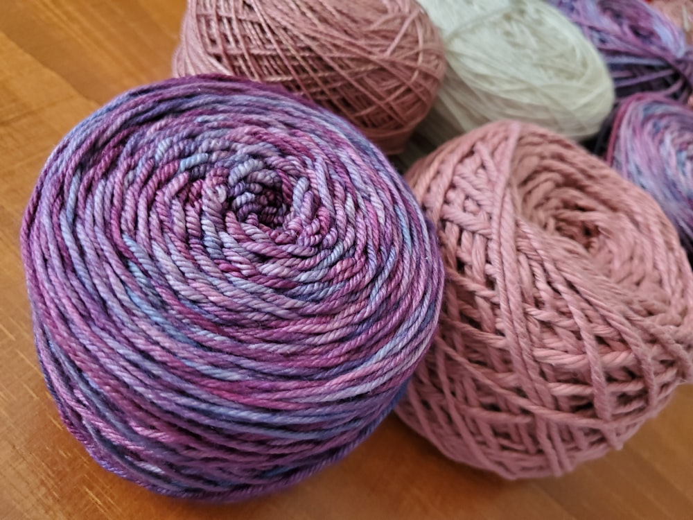 a group of balls of yarn sitting on top of a wooden floor