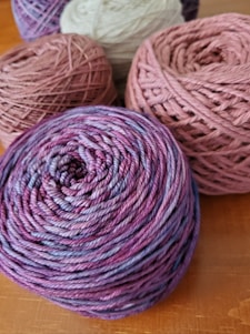 three skeins of yarn sitting on a table