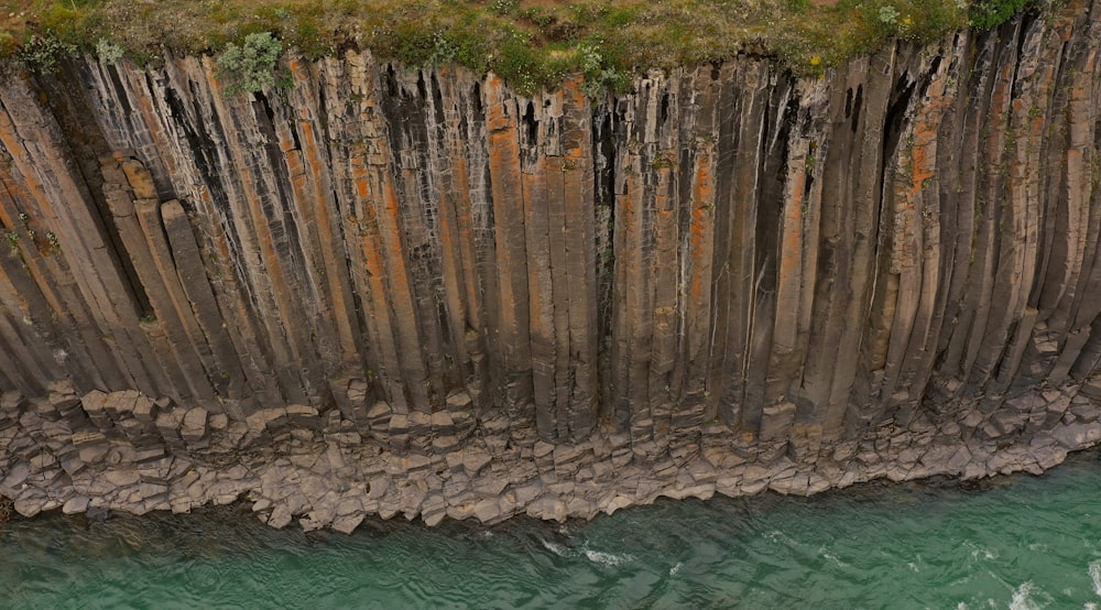 an aerial view of a cliff with a body of water