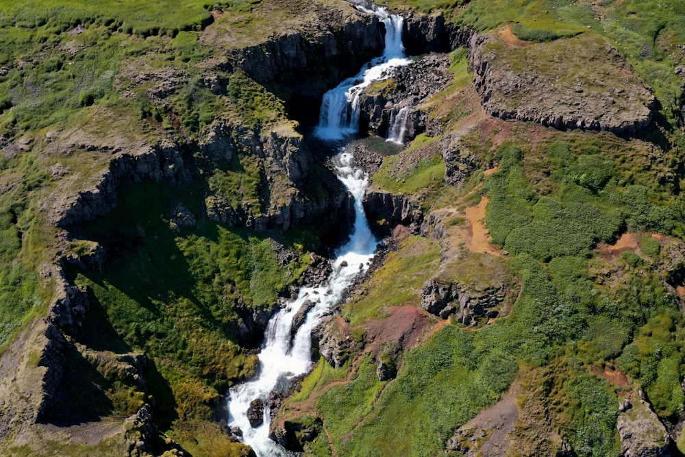 an aerial view of a waterfall in the mountains