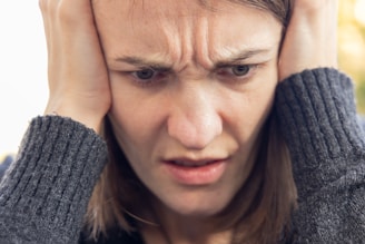 a man holding his head with both hands