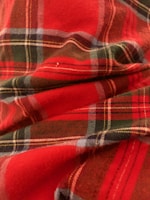 A close-up of a red plaid blanket draped over a chair.