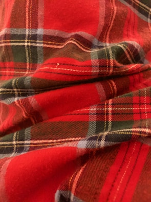 A close-up of a red plaid blanket draped over a chair.