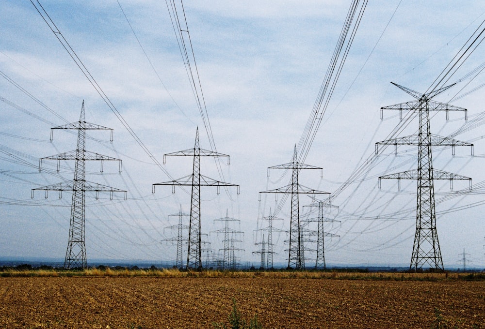 uma fileira de linhas de energia no meio de um campo