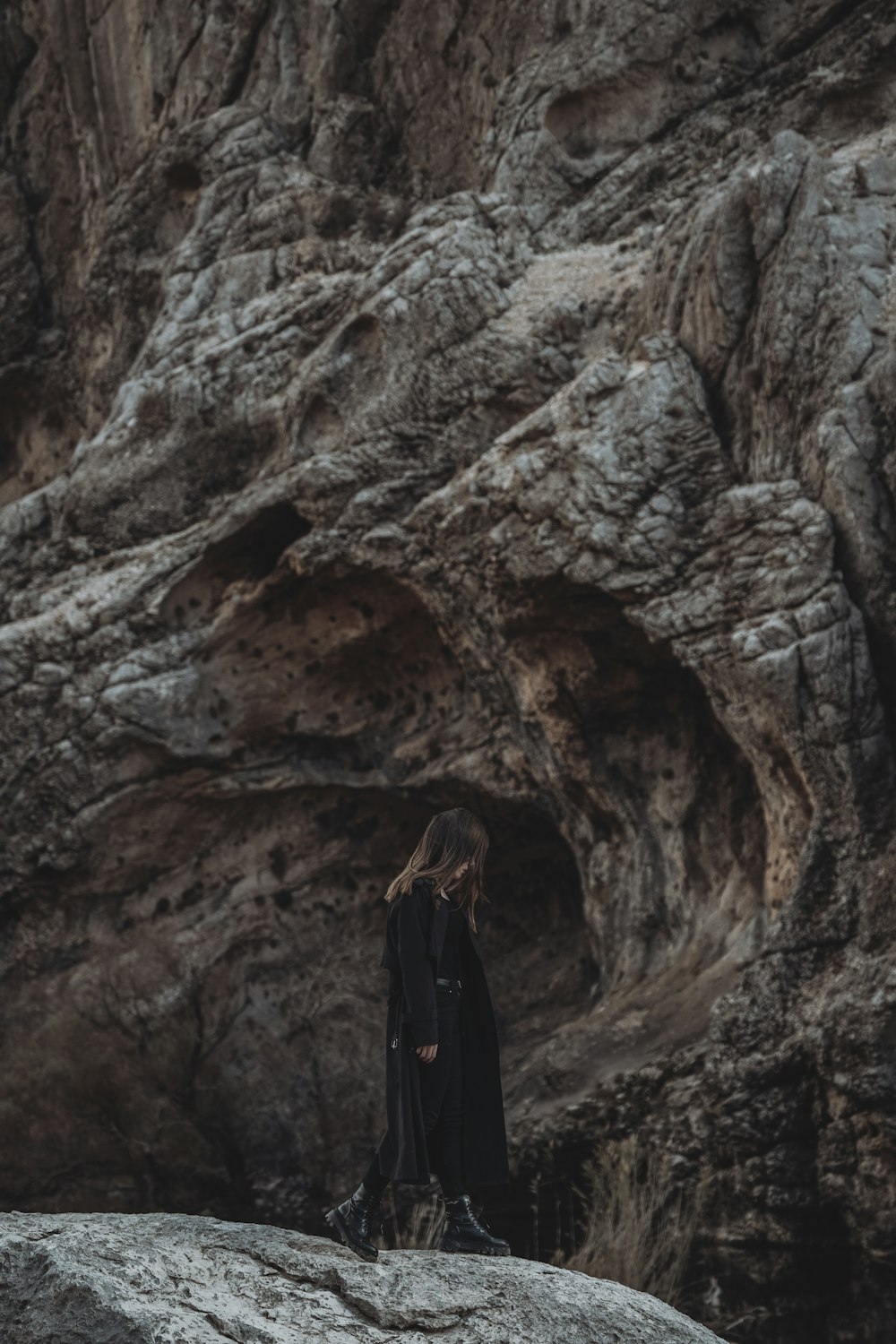 a woman standing on a rock in front of a mountain