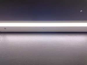 Close-up of a sleek, modern LED strip light installed in a commercial ceiling, showcasing its clean design and bright illumination.