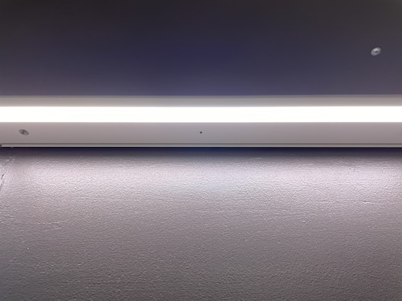 A sleek minimalist flush mount ceiling light brightening a modern dining area.