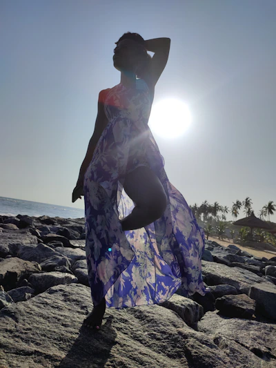 A vibrant scene of a model lounging on a driftwood log at sunset, wearing a relaxed, salty beach outfit that captures the vacation vibe.