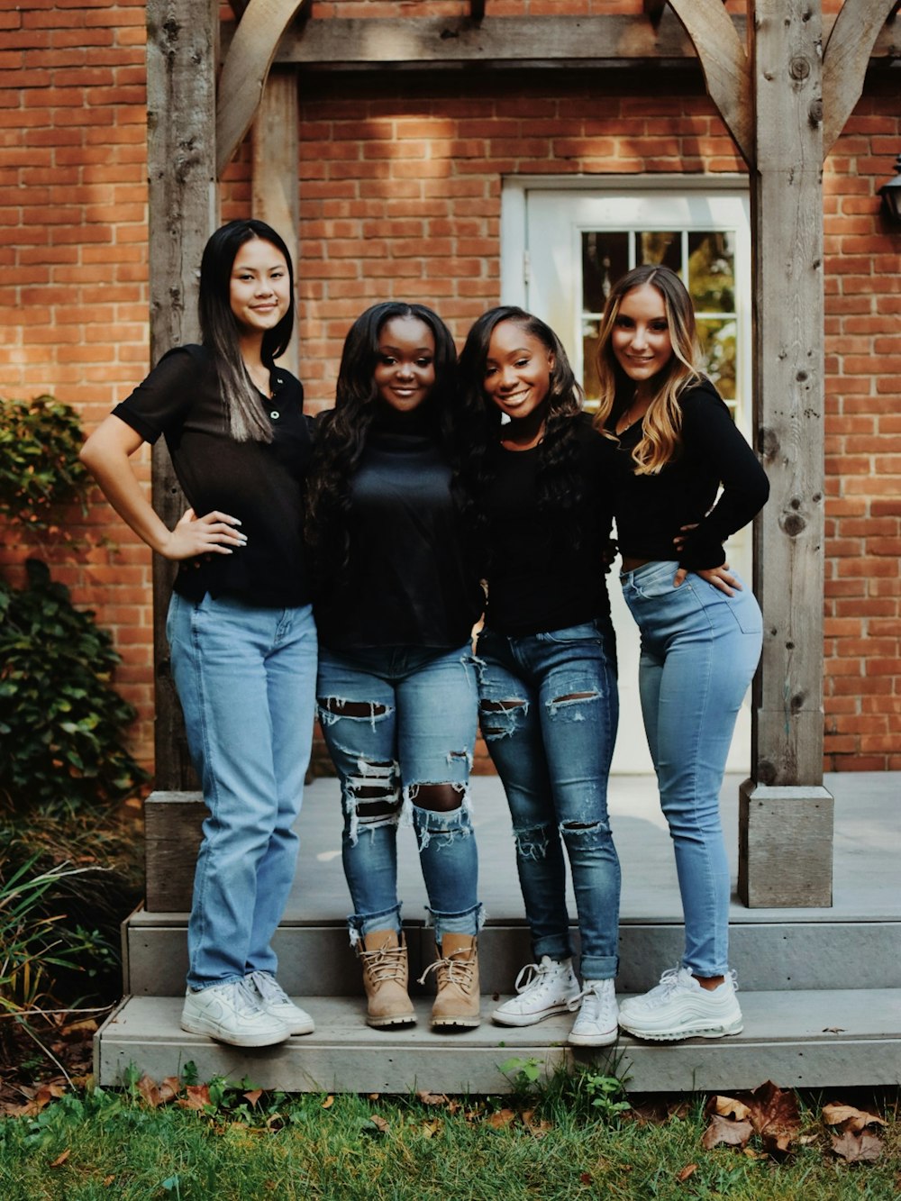 a group of women standing on a step in front of a building