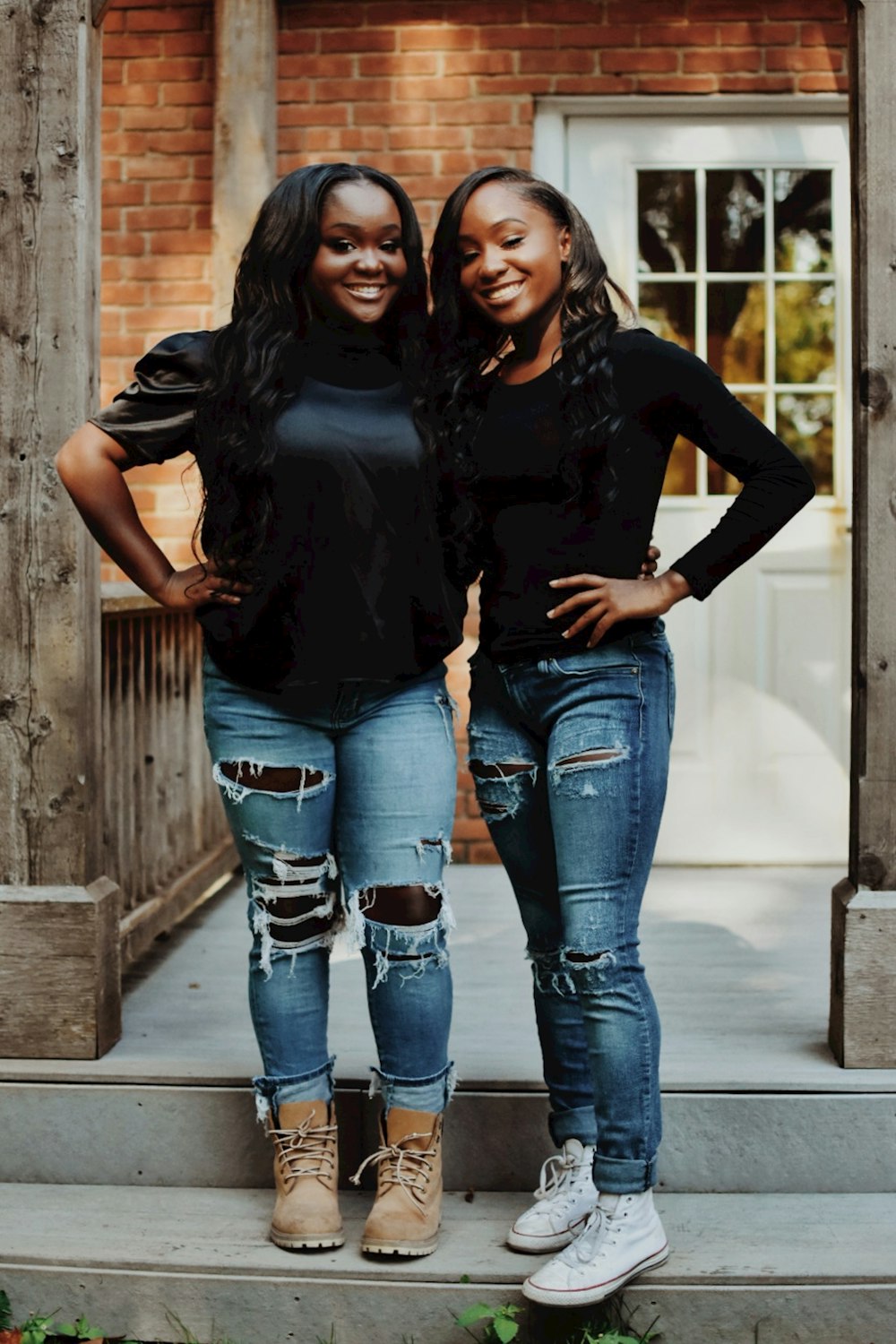 two women standing on the steps of a house